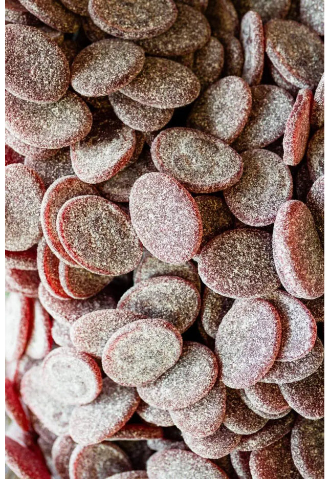 Close-up of sugar-coated red gummy candies shaped like lips.