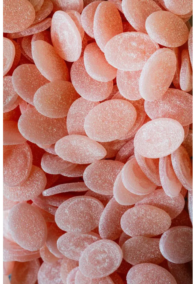 Close-up of numerous pink oval-shaped candies with a sugar coating.