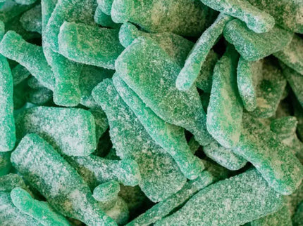 Close-up of green sour candy sticks coated with sugar.