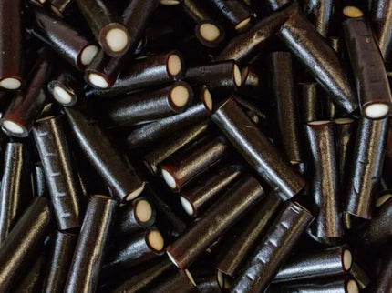 Close-up of shiny black licorice candy sticks.