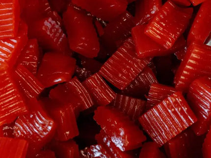 Close-up of red gummy candies with various shapes and textures.