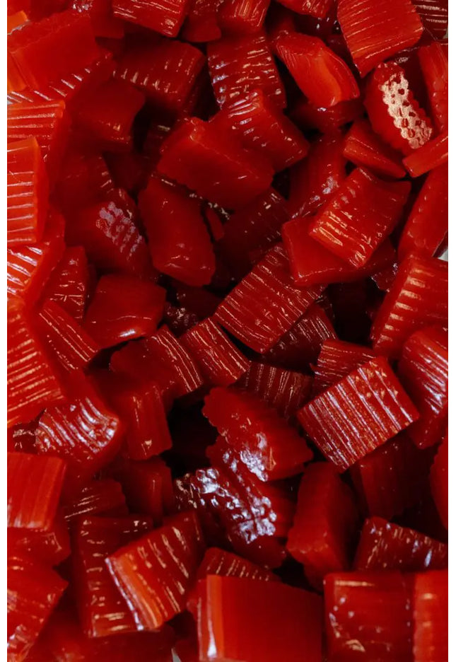 Close-up of red gummy candies with various shapes and textures.