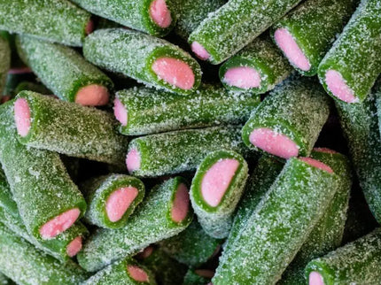 Green and pink sugar-coated candy sticks with a textured surface.
