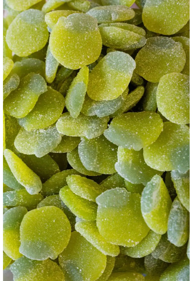 Close-up of green gummy candies coated with sugar crystals.