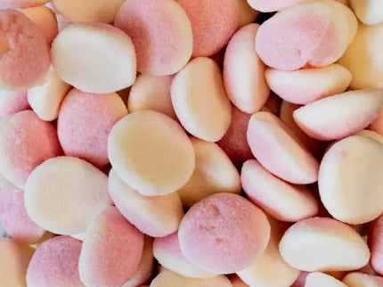 Close-up of pastel-colored candy buttons in pink, peach, and white.