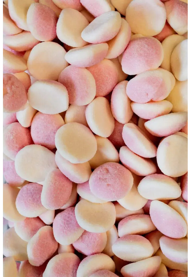 Close-up of pastel-colored candy buttons in pink, peach, and white.